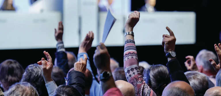 Público levantando la mano en una conferencia
