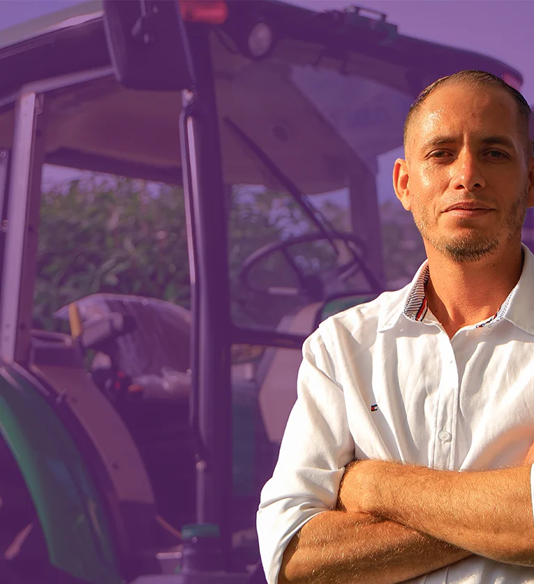Participante de los talleres de la Academia junto a un tractor